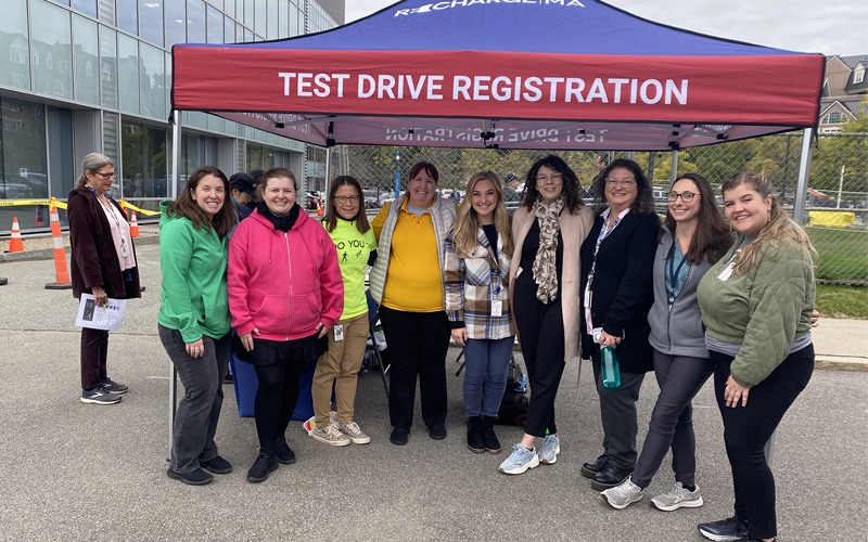 Event staff standing in front of the Test Drive Registration tent.